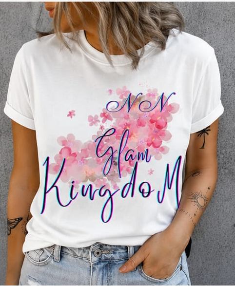 Person wearing a white t-shirt with 'Glam KingdoM' design on a gray background